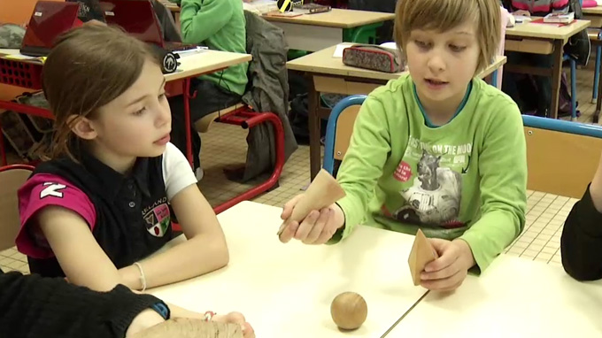 Deux enfants en train de manipuler une pyramide et un cône