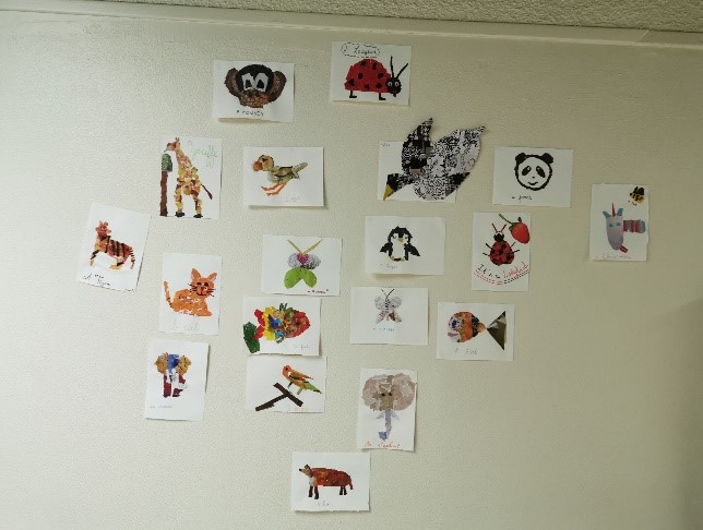 Photographie d’un mur sur lequel sont accrochés des petits dessins d’animaux.