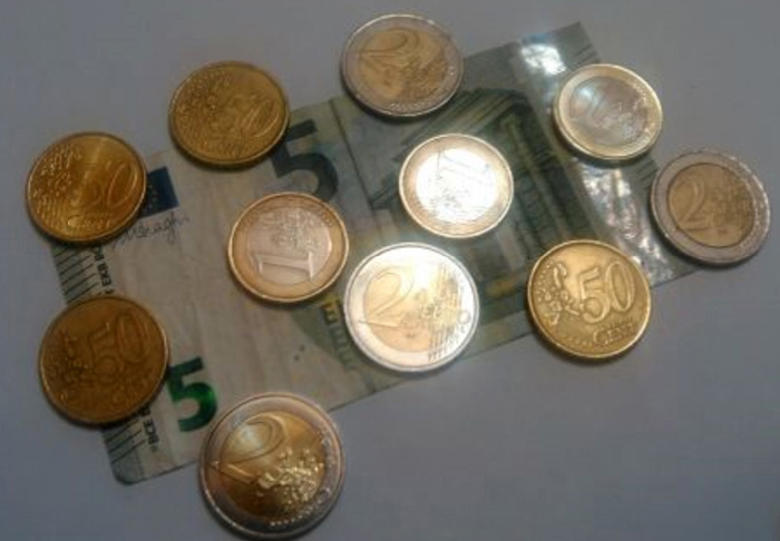 Photographie de monnaie : 1 billet de 5 euros, 4 pièces de 2 euros, 3 pièces de 1 euro et 4 pièces de 50 centimes.