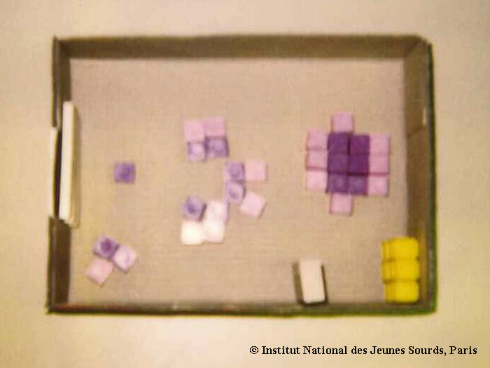 Photographie d’une maquette d’une salle de classe disposée en îlots.