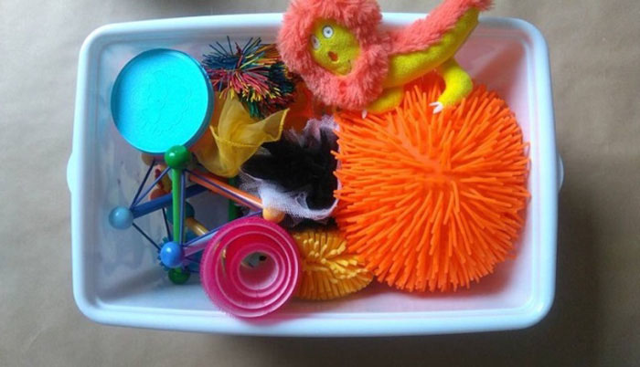 Photographie d’un malle contenant des petits objets géométriques et/ou texturés.